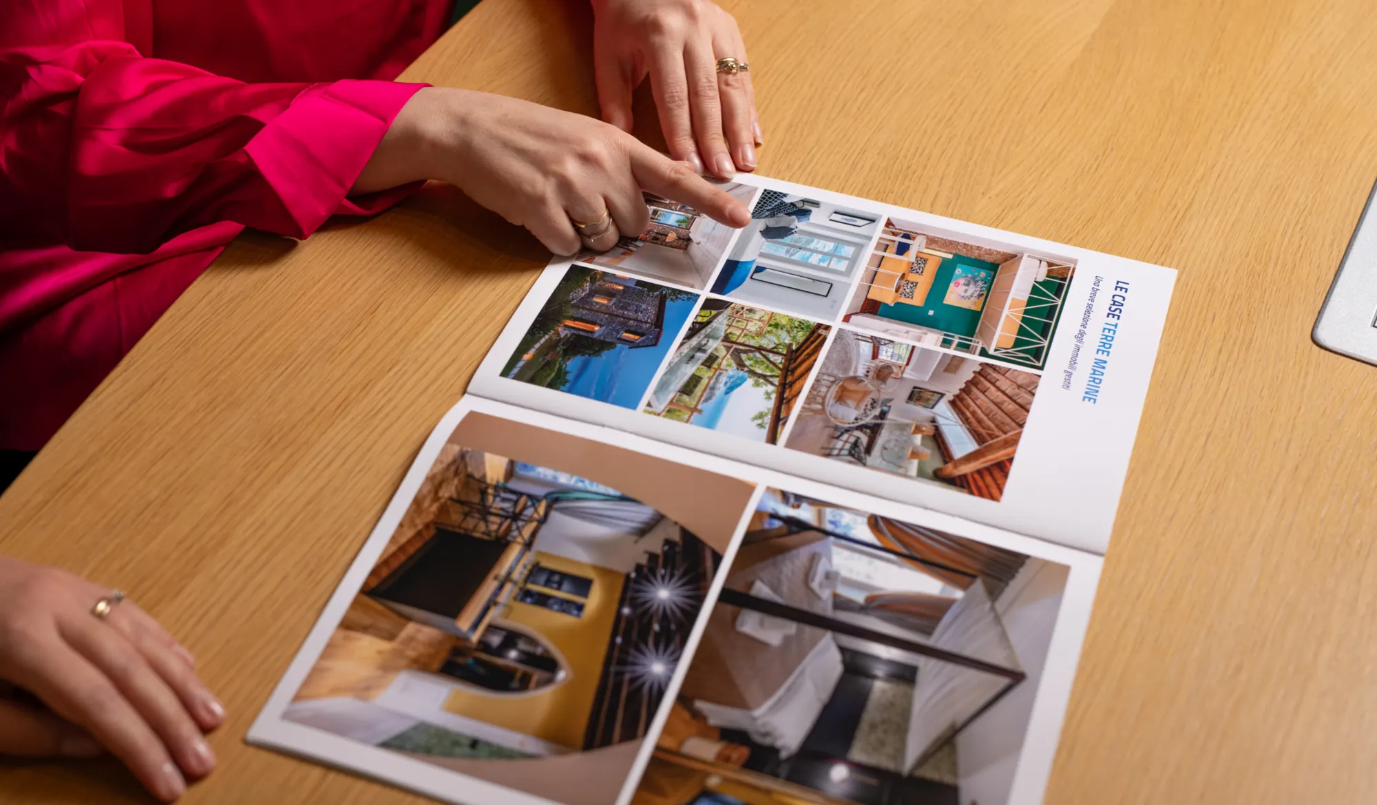 Una persona indica le foto di abitazioni in una brochure immobiliare